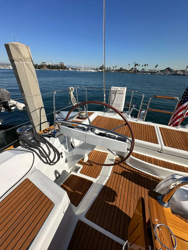 Slide: The Image of 2013 Jeanneau 57 yacht with wooden deck, docked in a sunny marina. - 31