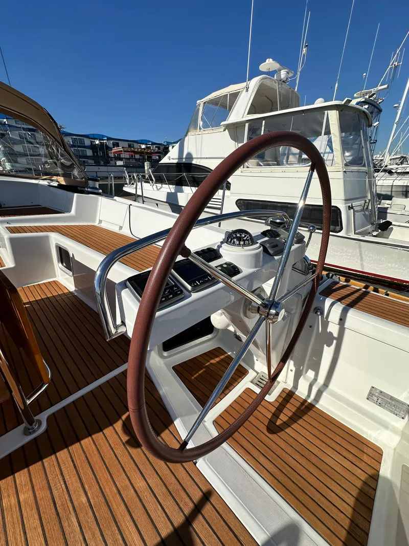 Slide: The Image of 2013 Jeanneau 57 yacht helm with wooden deck, docked in marina. - 41