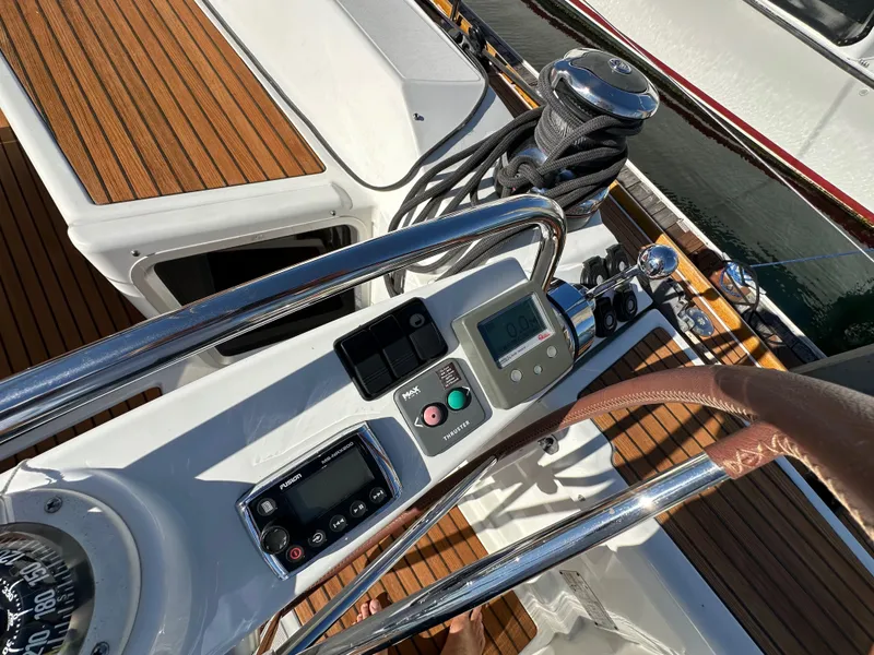 Slide: The Image of Jeanneau 57 yacht cockpit controls, 2013 model, featuring navigation instruments and teak decking. - 43