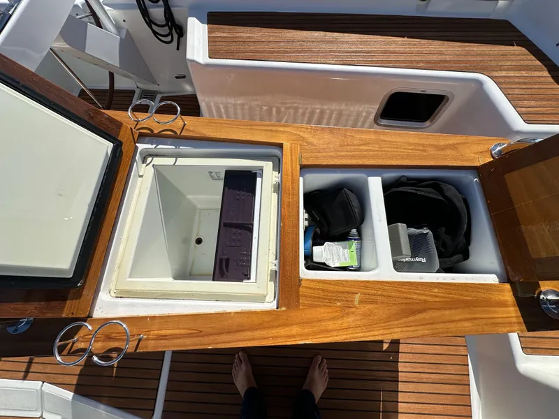 Slide: The Image of Jeanneau 57 yacht cockpit storage compartments, 2013 model, with wooden finish and open lids. - 46
