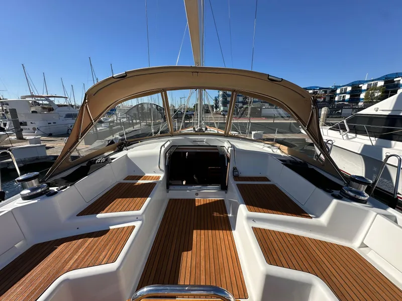 Slide: The Image of 2013 Jeanneau 57 sailboat cockpit with teak flooring and canopy in marina. - 47