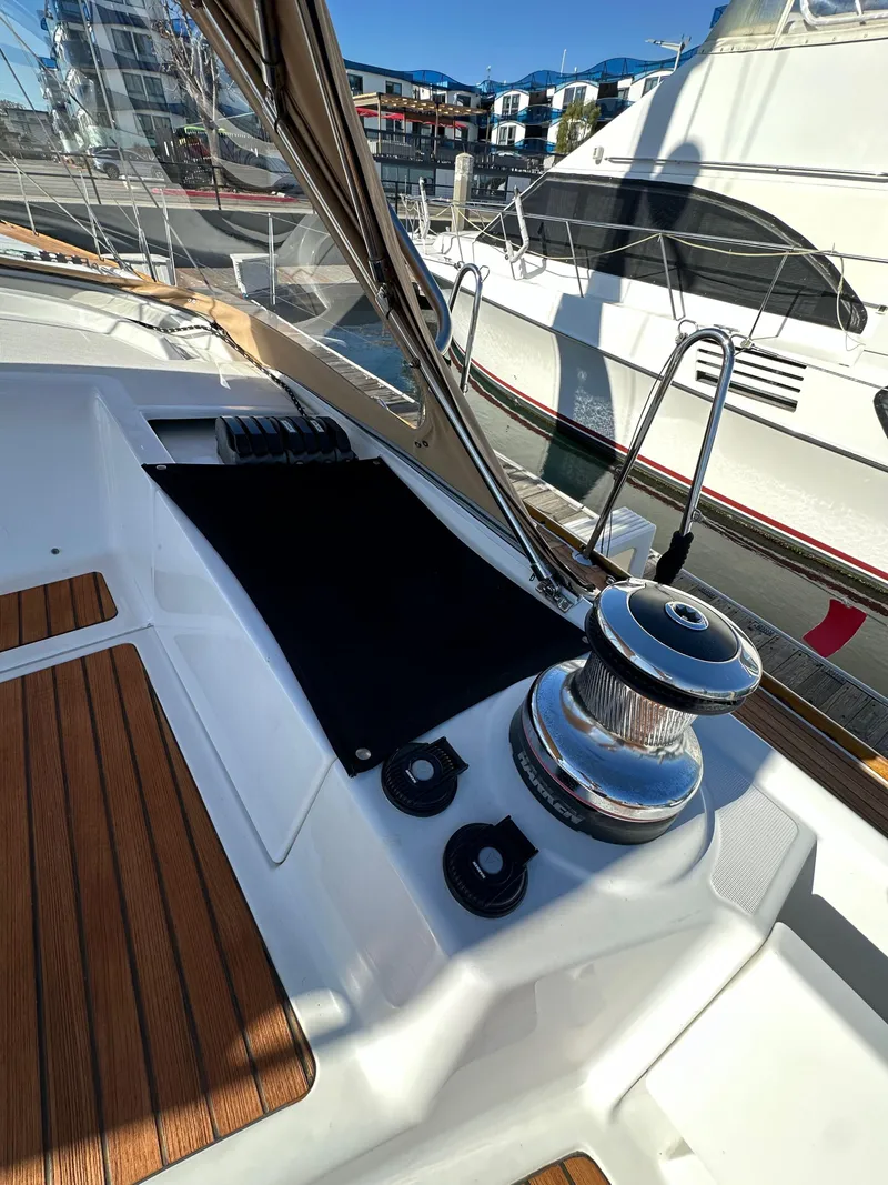 Slide: The Image of Jeanneau 57 sailboat deck, 2013 model, featuring winch and teak flooring. - 48