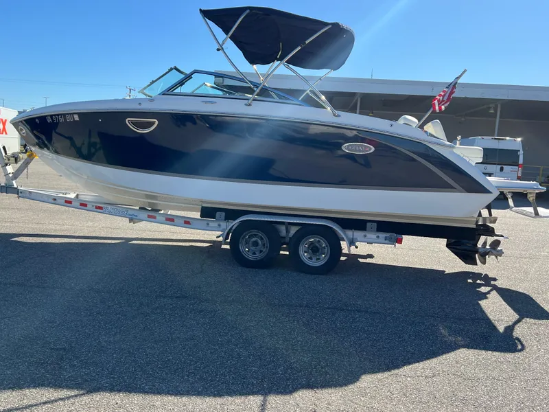 Slide: The Image of 2014 Cobalt R5 boat on trailer, navy and white, with canopy and American flag. - 12