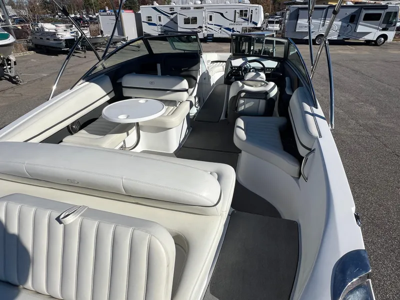 Slide: The Image of 2014 Cobalt R5 boat with spacious white interior and seating, parked in a marina. - 21