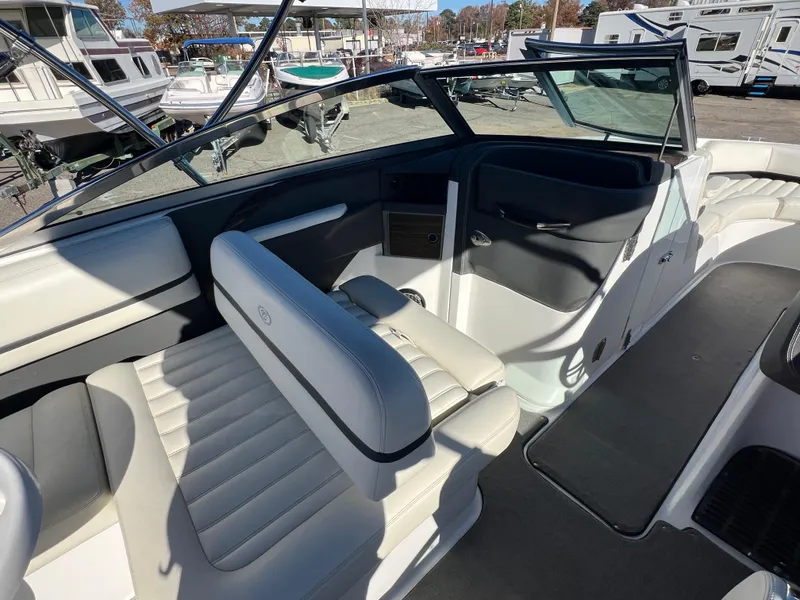 Slide: The Image of 2014 Cobalt R5 boat interior with white and black seating, docked near other boats. - 26