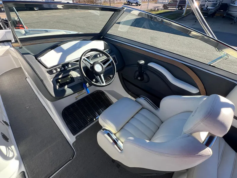 Slide: The Image of 2014 Cobalt R5 boat cockpit with steering wheel and white captain's chair. - 28