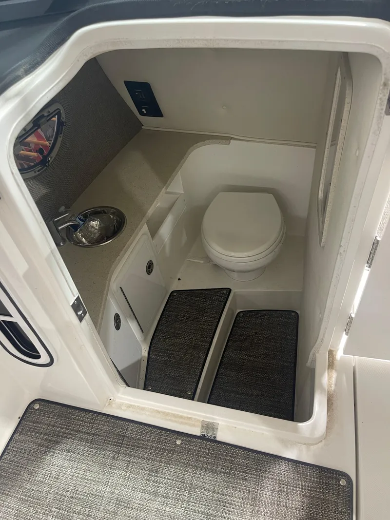 Slide: The Image of 2022 Cobalt 30 SC boat interior with compact bathroom and sink. - 16