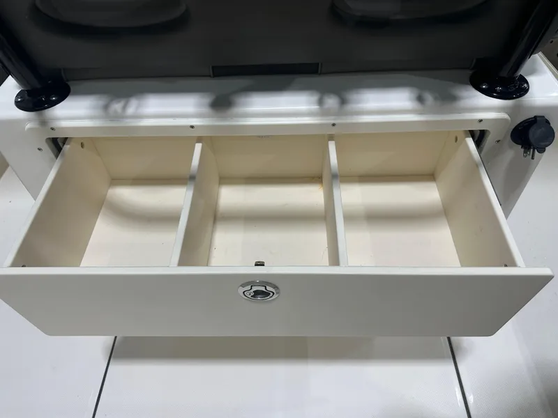 Slide: The Image of Open storage drawer in 2023 Sea Born FX 25 boat, featuring three compartments. - 20