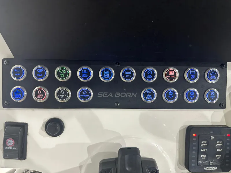 Slide: The Image of Control panel of 2023 Sea Born FX 25 boat with labeled buttons and switches. - 25