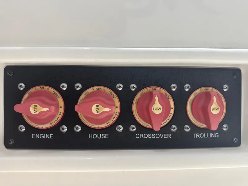 Slide: The Image of Control panel with four red switches for engine, house, crossover, and trolling on a 2023 Sea Born FX 25. - 48