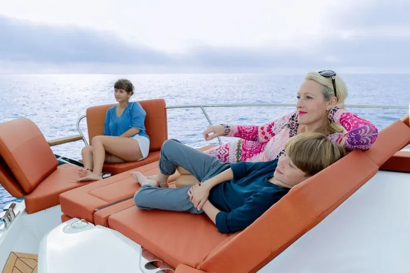 Slide: The Image of People relaxing on a 2025 Sealine C430 yacht, enjoying the ocean view. - 13