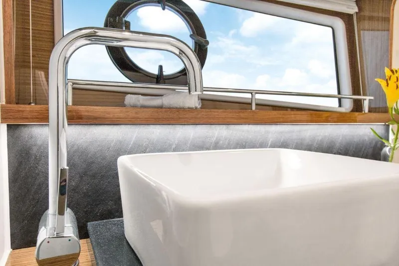 Slide: The Image of Modern bathroom sink and faucet on 2025 Sealine C430 yacht, with porthole window view. - 41