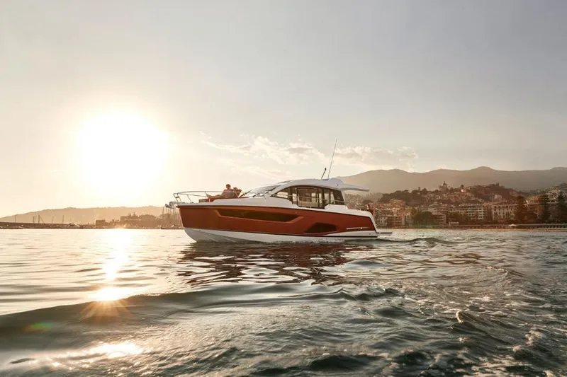 Slide: The Image of 2025 Sealine C430 yacht cruising at sunset near coastal city. - 5