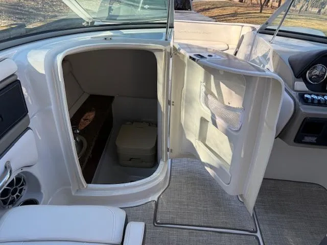 Slide: The Image of 2020 Crownline Eclipse E255 XS boat interior with open storage compartment and seating area. - 12