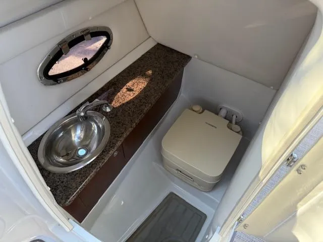 Slide: The Image of 2020 Crownline Eclipse E255 XS boat bathroom with sink and portable toilet. - 13