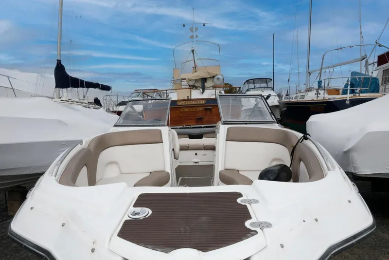 Slide: The Image of 2011 Yamaha Boats 242 Limited, docked with other vessels under a clear blue sky. - 10