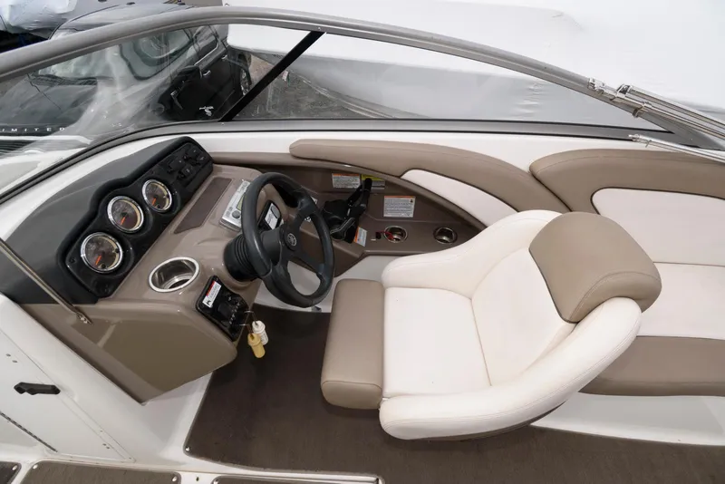 Slide: The Image of 2011 Yamaha Boats 242 Limited interior with steering wheel and beige seating. - 5