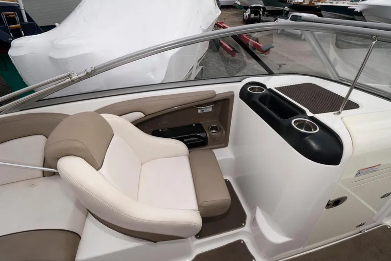 Slide: The Image of Interior of 2011 Yamaha Boats 242 Limited, featuring beige and white seating with cup holders. - 6