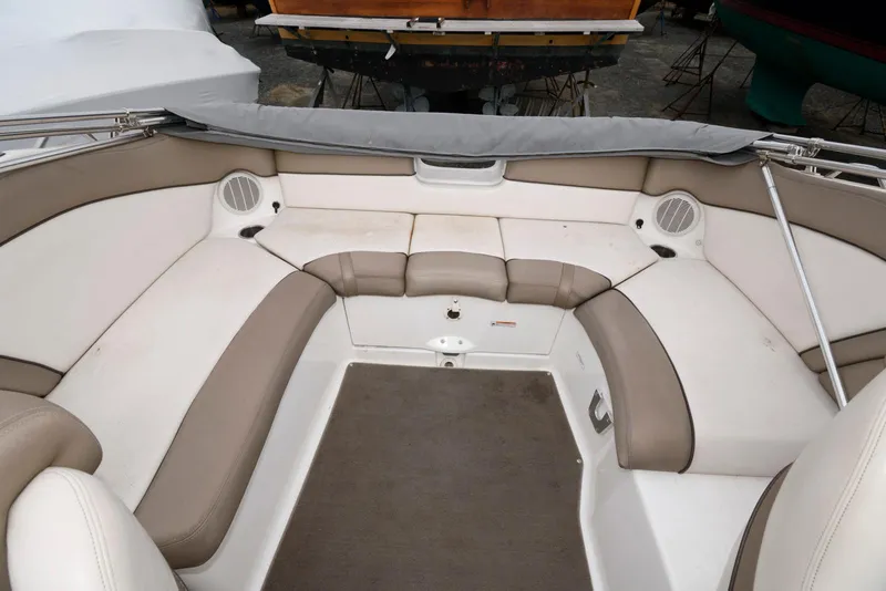 Slide: The Image of 2011 Yamaha Boats 242 Limited interior seating area with beige and white upholstery. - 9