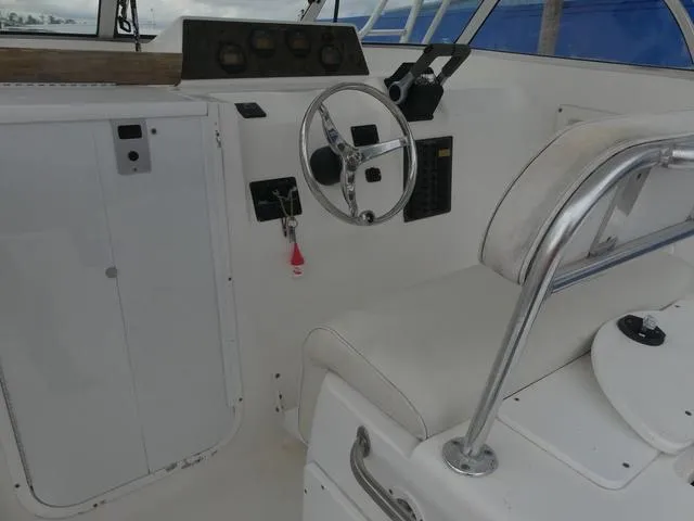 Slide: The Image of 2003 Pro Sports Pro Kat 2860 boat cockpit with steering wheel and control panel. - 16