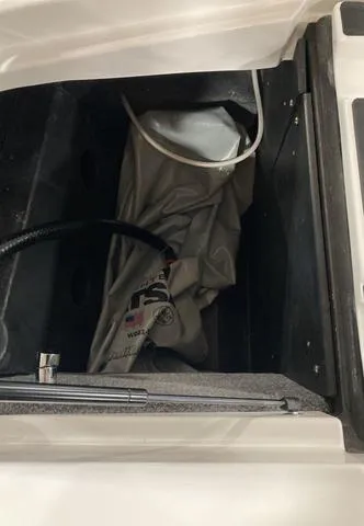 Slide: The Image of 2021 Malibu 23 LSV storage compartment with equipment inside. - 8