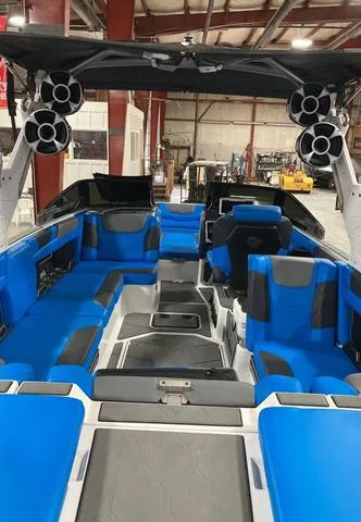 Slide: The Image of 2021 Malibu M240 boat interior with blue seating and advanced audio system. - 4