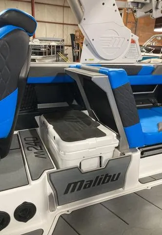 Slide: The Image of 2021 Malibu M240 boat interior with blue and black seating and storage compartment. - 8