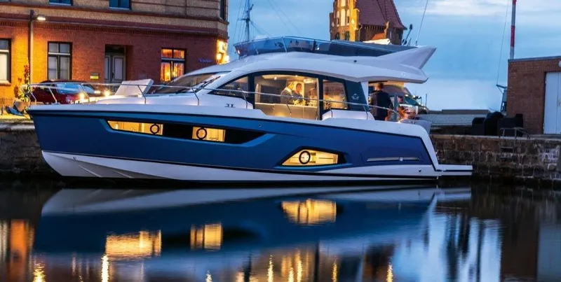Slide: The Image of 2025 Sealine F430 yacht docked at night, illuminated against a waterfront backdrop. - 10