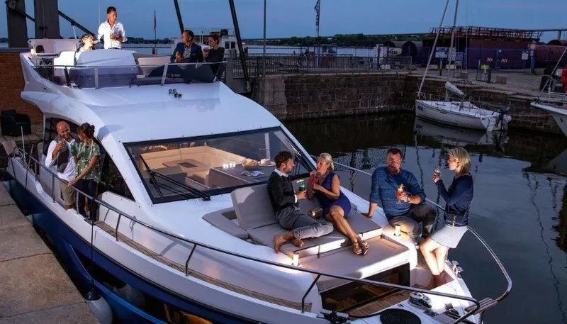 Slide: The Image of People enjoying an evening on a 2025 Sealine F430 yacht docked at a marina. - 11