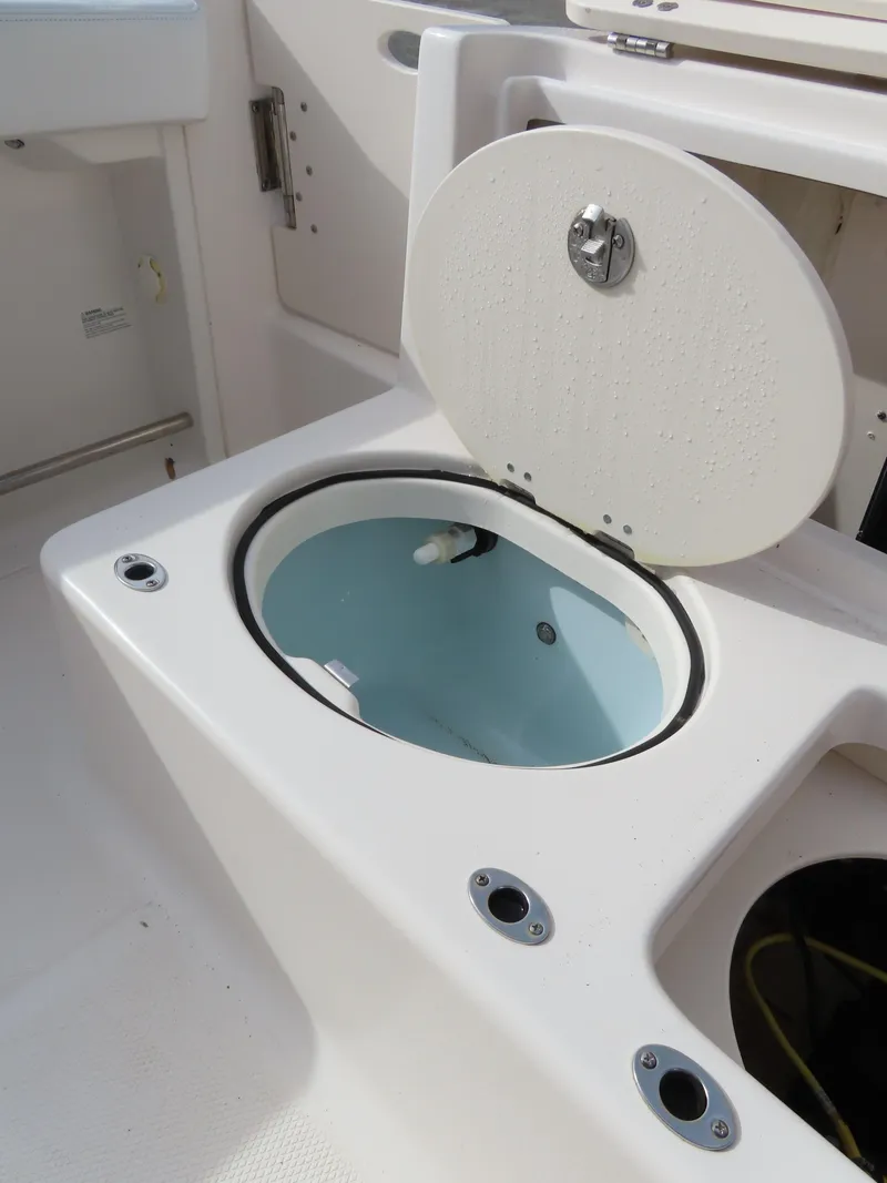 Slide: The Image of 2018 Robalo R222 Center Console livewell with open lid, showcasing interior features. - 25