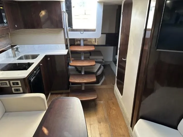 Slide: The Image of Interior of 2017 Sea Ray Sundancer 350 Coupe with modern kitchen and wooden stairs. - 2