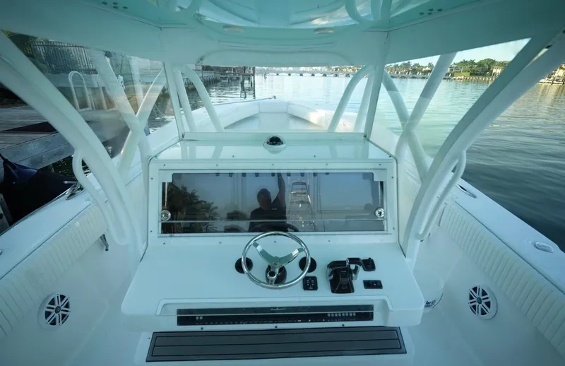 Slide: The Image of 2016 SeaHunter 41 Tournament boat cockpit with steering wheel and controls, docked by calm waters. - 9