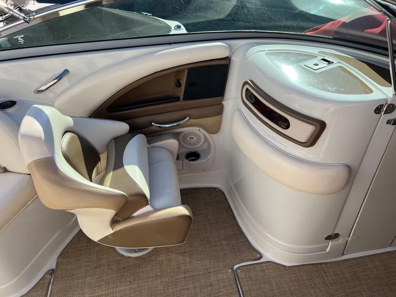 Slide: The Image of 2013 Crownline Q4 boat interior with beige seating and dashboard. - 11