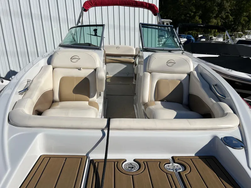 Slide: The Image of 2013 Crownline Q4 boat interior with beige seating and wood accents. - 16