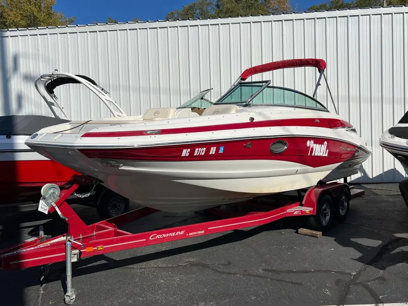 The Image of 2013 Crownline Q4 boat on red trailer, parked outdoors. - 0