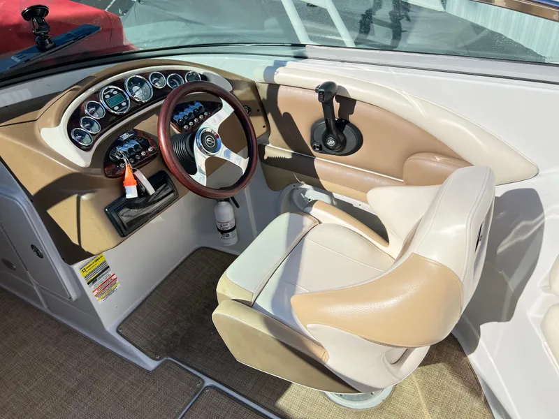 Slide: The Image of 2013 Crownline Q4 boat interior with steering wheel and beige seating. - 13