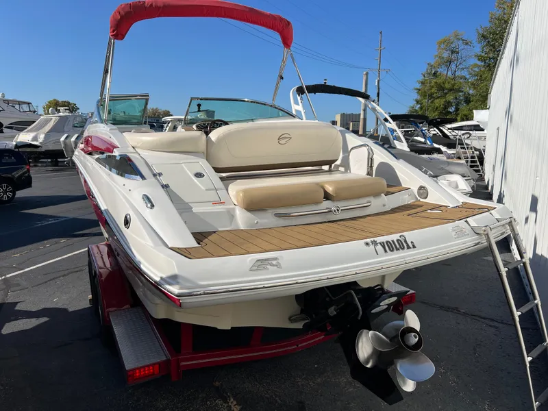 Slide: The Image of 2013 Crownline Q4 boat with red canopy on trailer, parked outdoors. - 3