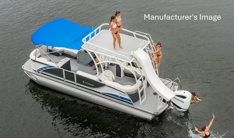 The Image of 2024 Godfrey Monaco 235SD pontoon boat with slide, blue canopy, and people enjoying water activities. - 0