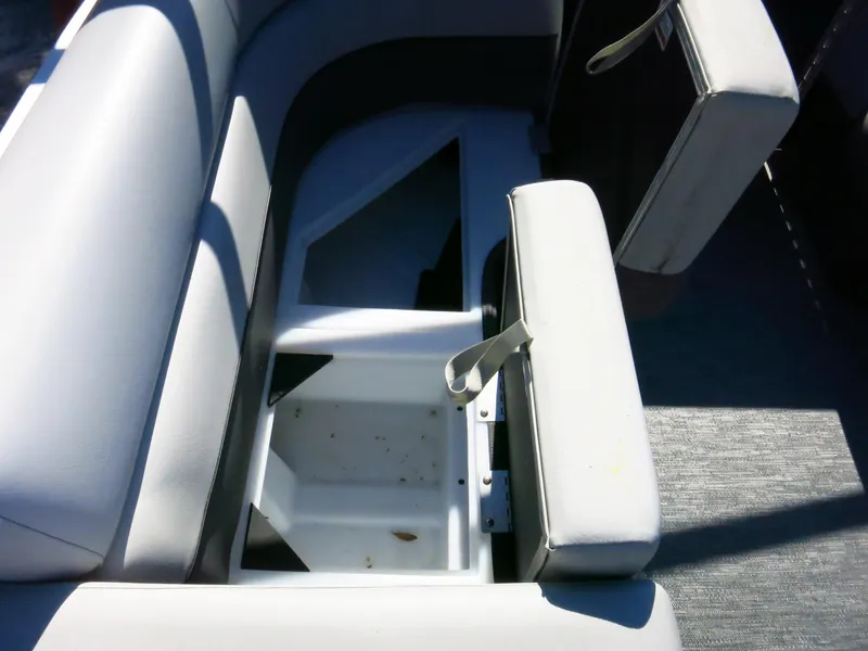 Slide: The Image of 2024 Godfrey Monaco 235SD boat seat storage compartment, open with visible interior. - 13