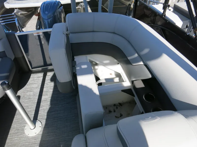 Slide: The Image of 2024 Godfrey Monaco 235SD boat interior with gray seating and storage area. - 20