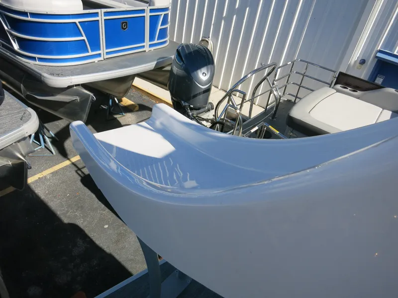 Slide: The Image of 2024 Godfrey Monaco 235SD boat with slide and outboard motor, docked outdoors. - 21