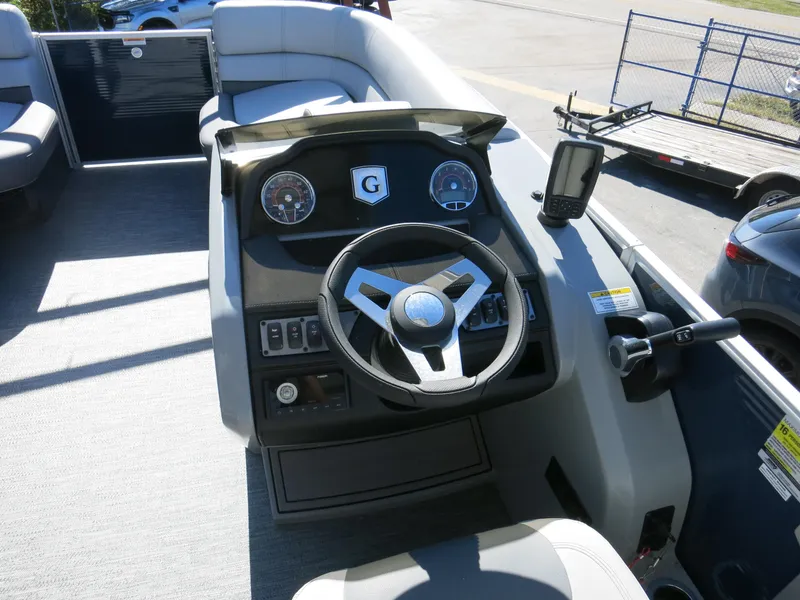 Slide: The Image of 2024 Godfrey Monaco 235SD boat dashboard with steering wheel and controls. - 8