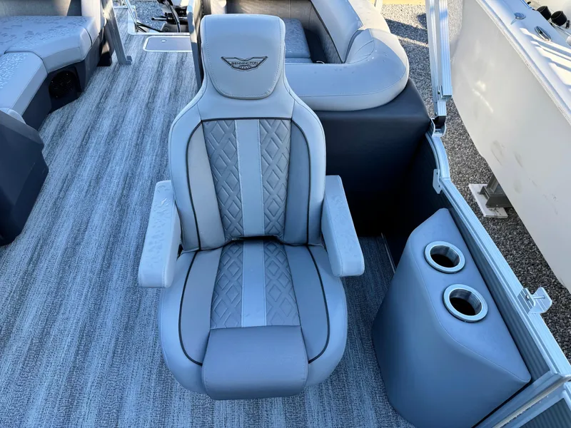Slide: The Image of 2025 Bennington 24 MFB boat interior with luxurious captain's chair and cup holders. - 16