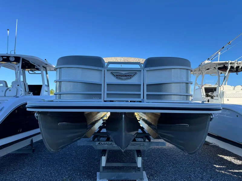 Slide: The Image of 2025 Bennington 24 MFB pontoon boat on display between two other boats. - 3