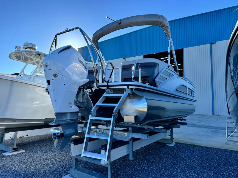 Slide: The Image of 2025 Bennington 24 MFB pontoon boat on display with outboard motor. - 4