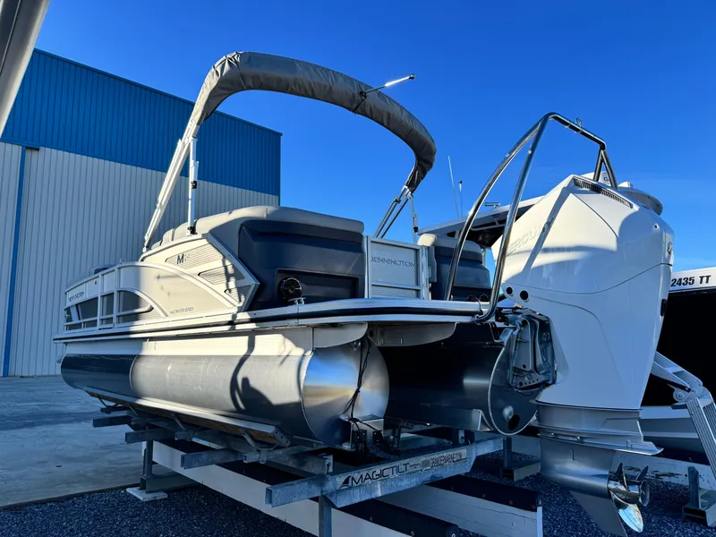 Slide: The Image of 2025 Bennington 24 MFB pontoon boat on trailer, docked outdoors. - 6