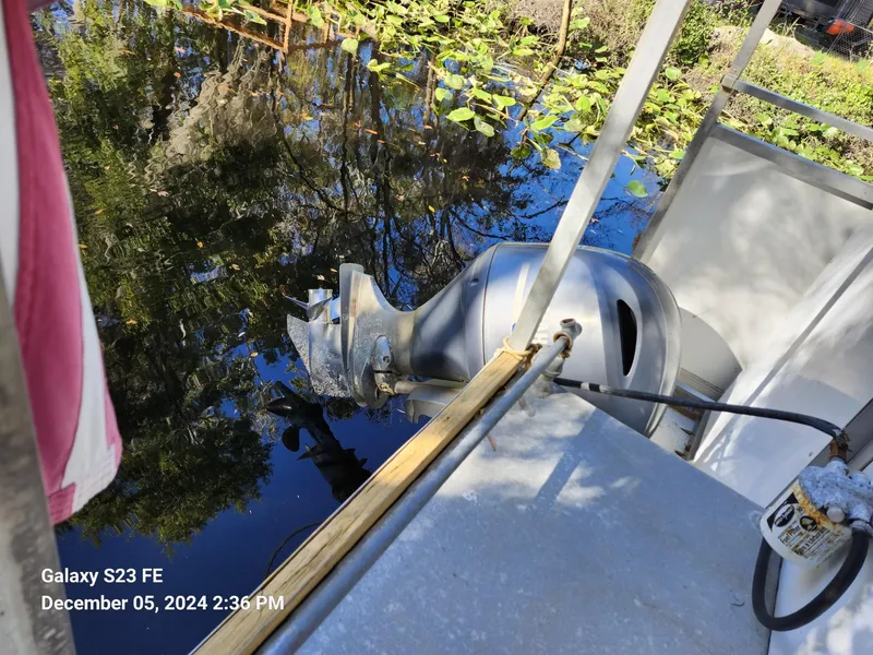Slide: The Image of Boat motor on a 2016 Rover Marine Carolina Rover 40, docked by a leafy waterway. - 17