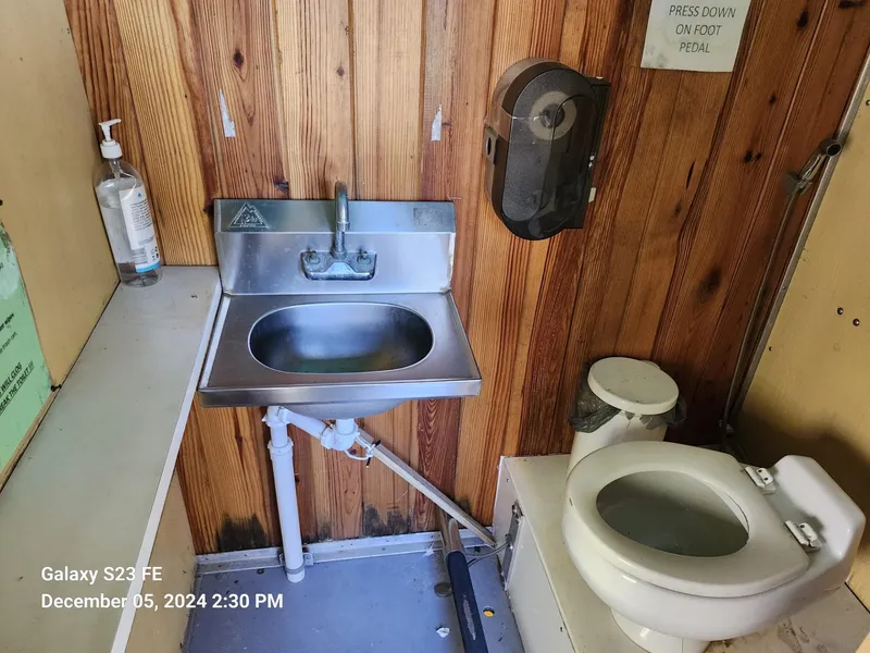 Slide: The Image of Small bathroom with stainless steel sink, toilet, and wooden walls on a 2016 Rover Marine Carolina Rover 40. - 21