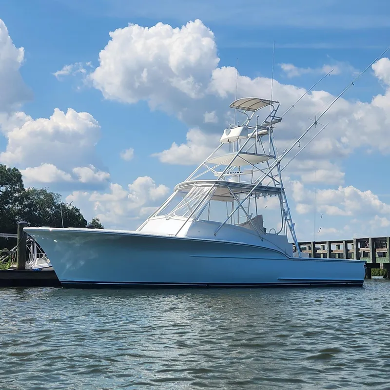 Slide: The Image of 1996 Jersey Devil boat on calm water under a blue sky with clouds. - 1