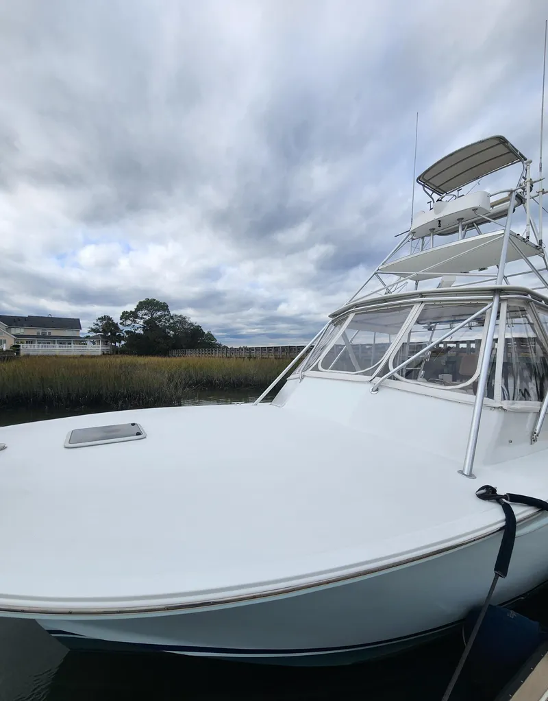 Slide: The Image of 1996 Jersey Devil boat with tower, docked under cloudy skies. - 10